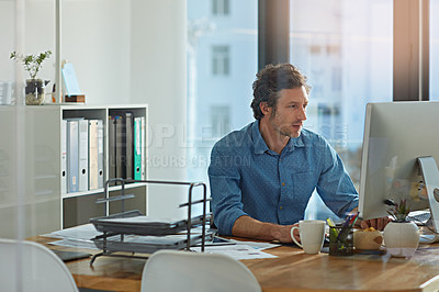 Buy stock photo Shot of a businessman working on a computer in an office