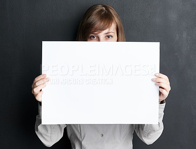 Buy stock photo Portrait, poster and mockup with a woman in studio on a dark background for information or announcement. Branding, advertising or marketing with a young female brand ambassador holding a blank sign