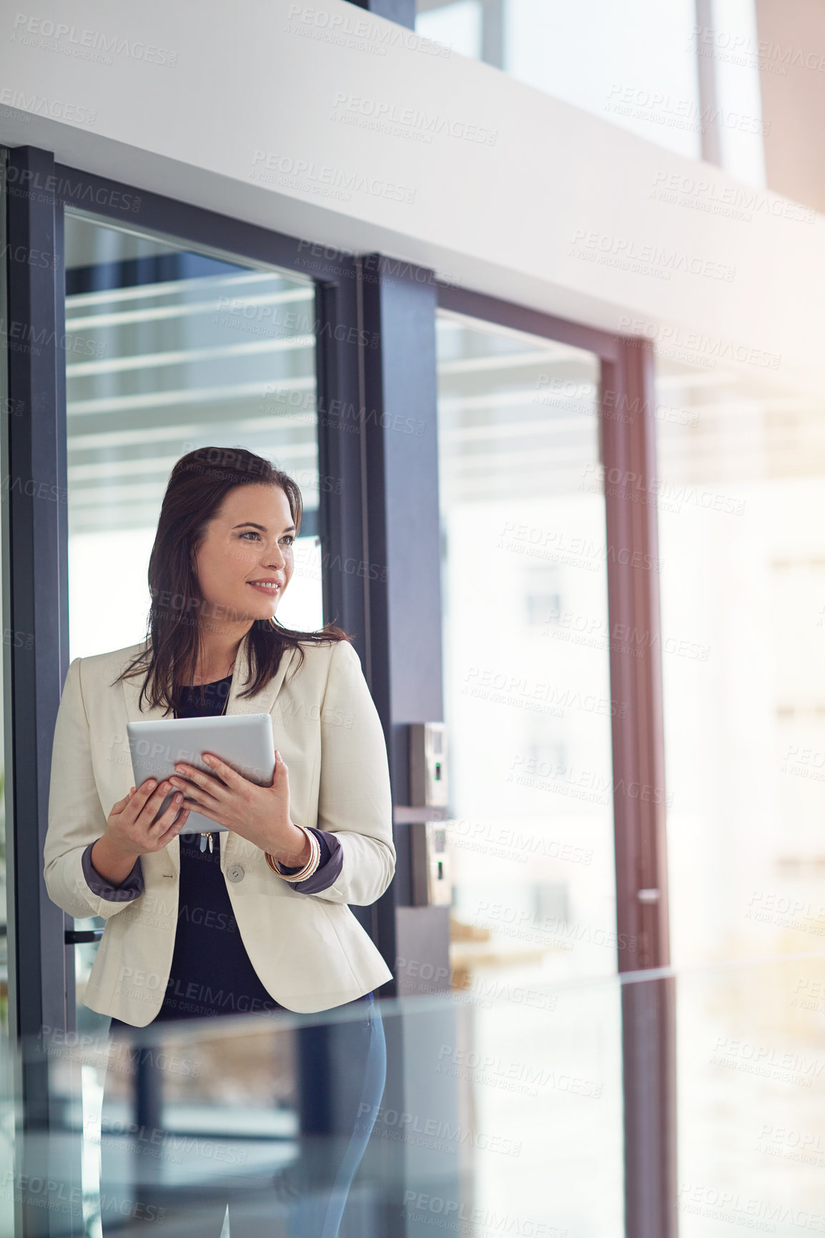 Buy stock photo Shot of a young businesswomen using a digital tablet in an office