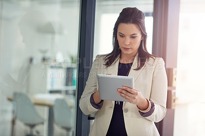 Buy stock photo Shot of a young businesswomen using a digital tablet in an office