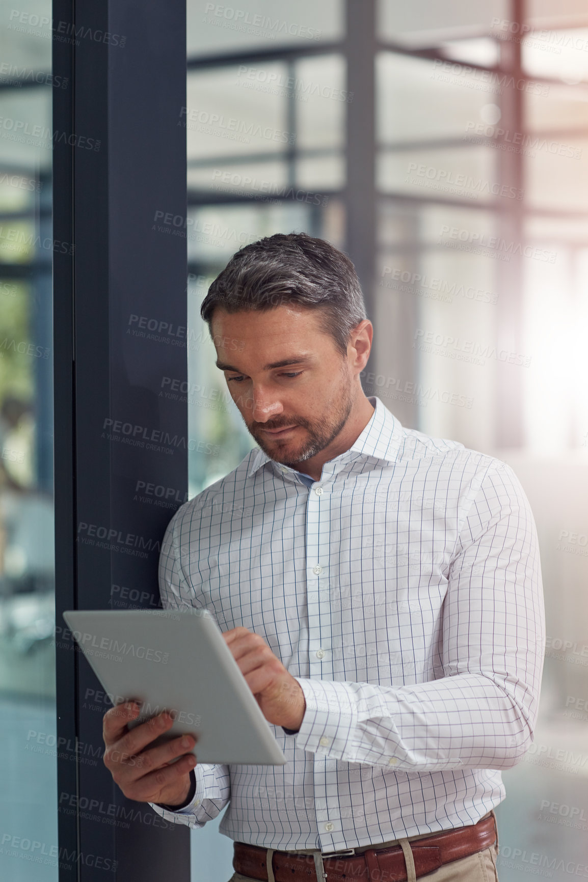 Buy stock photo Shot of a businessman using a digital tablet in an office