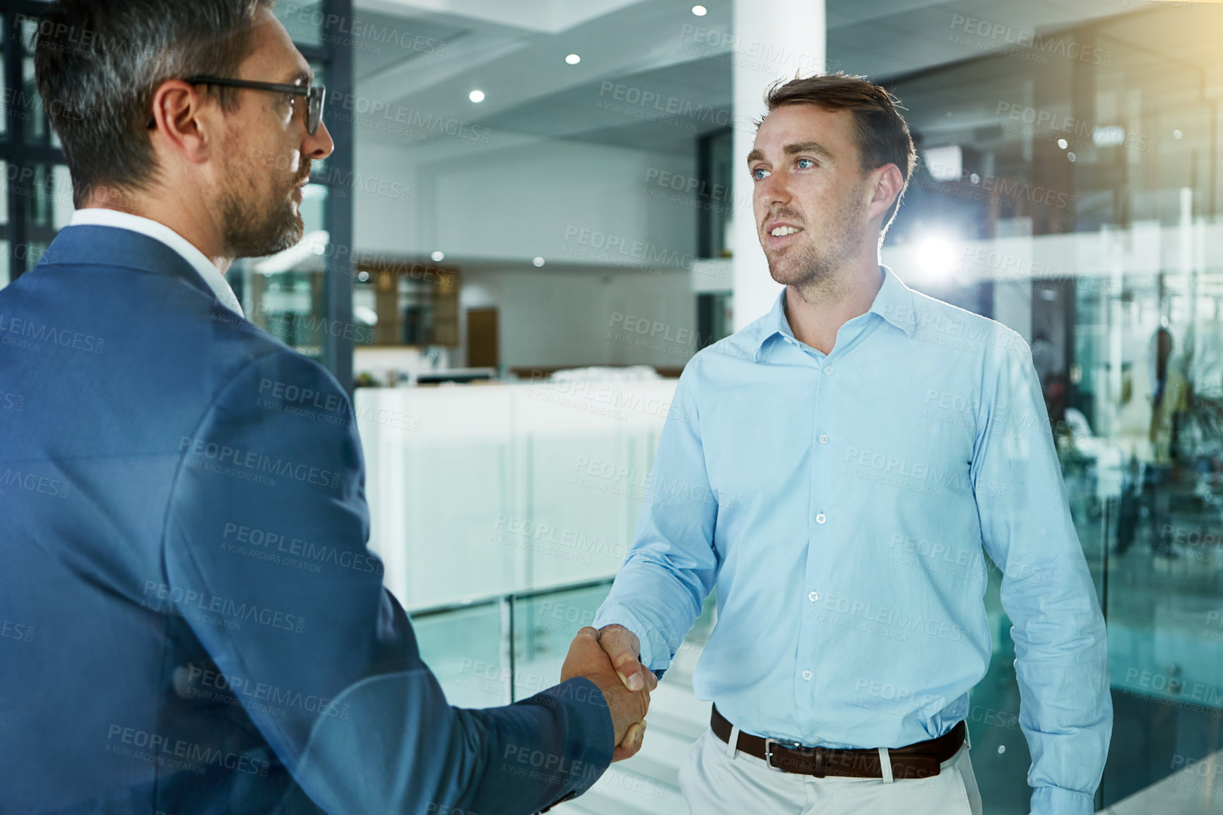 Buy stock photo Shot of two businessmen shaking hands in an office