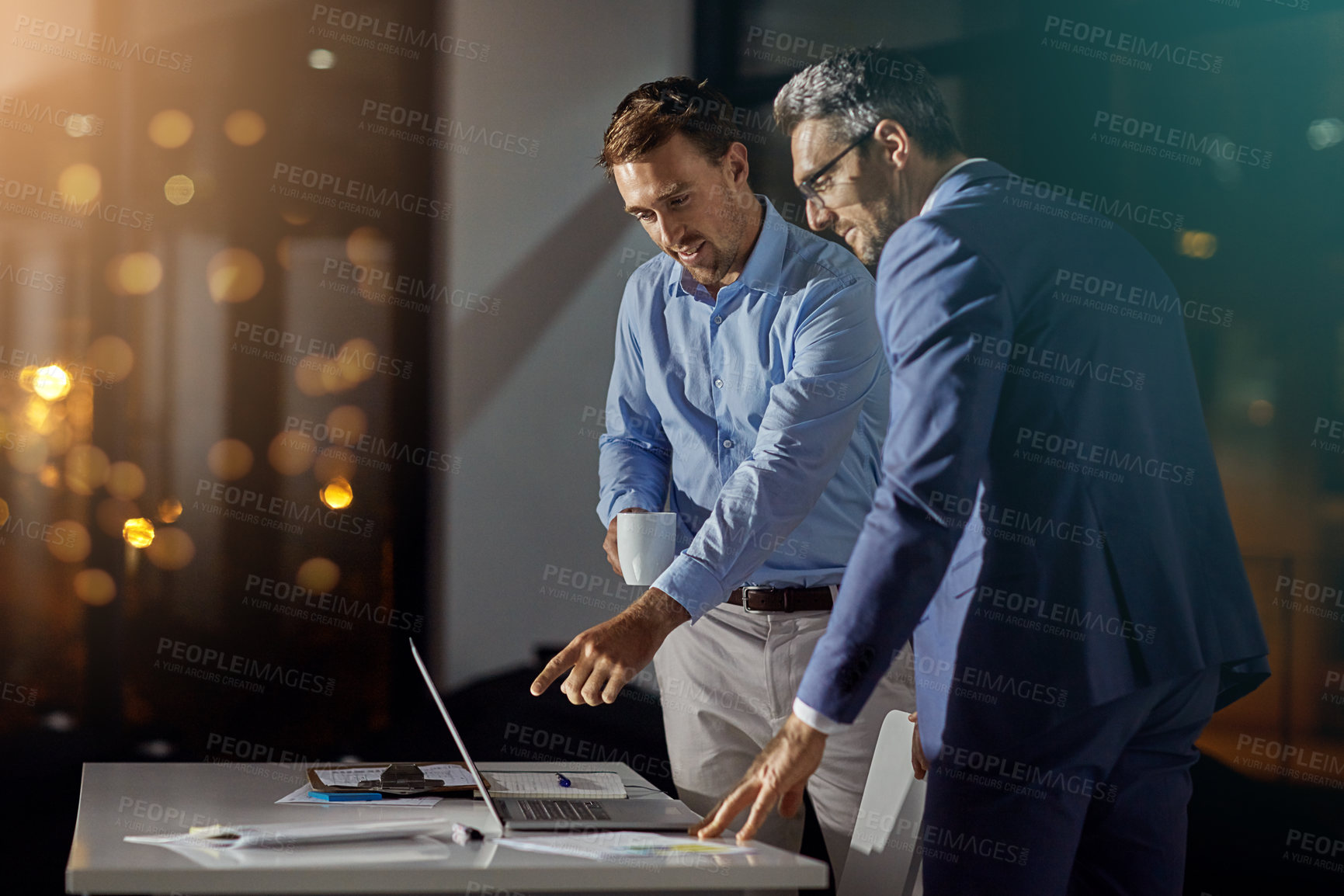 Buy stock photo Shot of a coworkers using a laptop together while woking late at the office