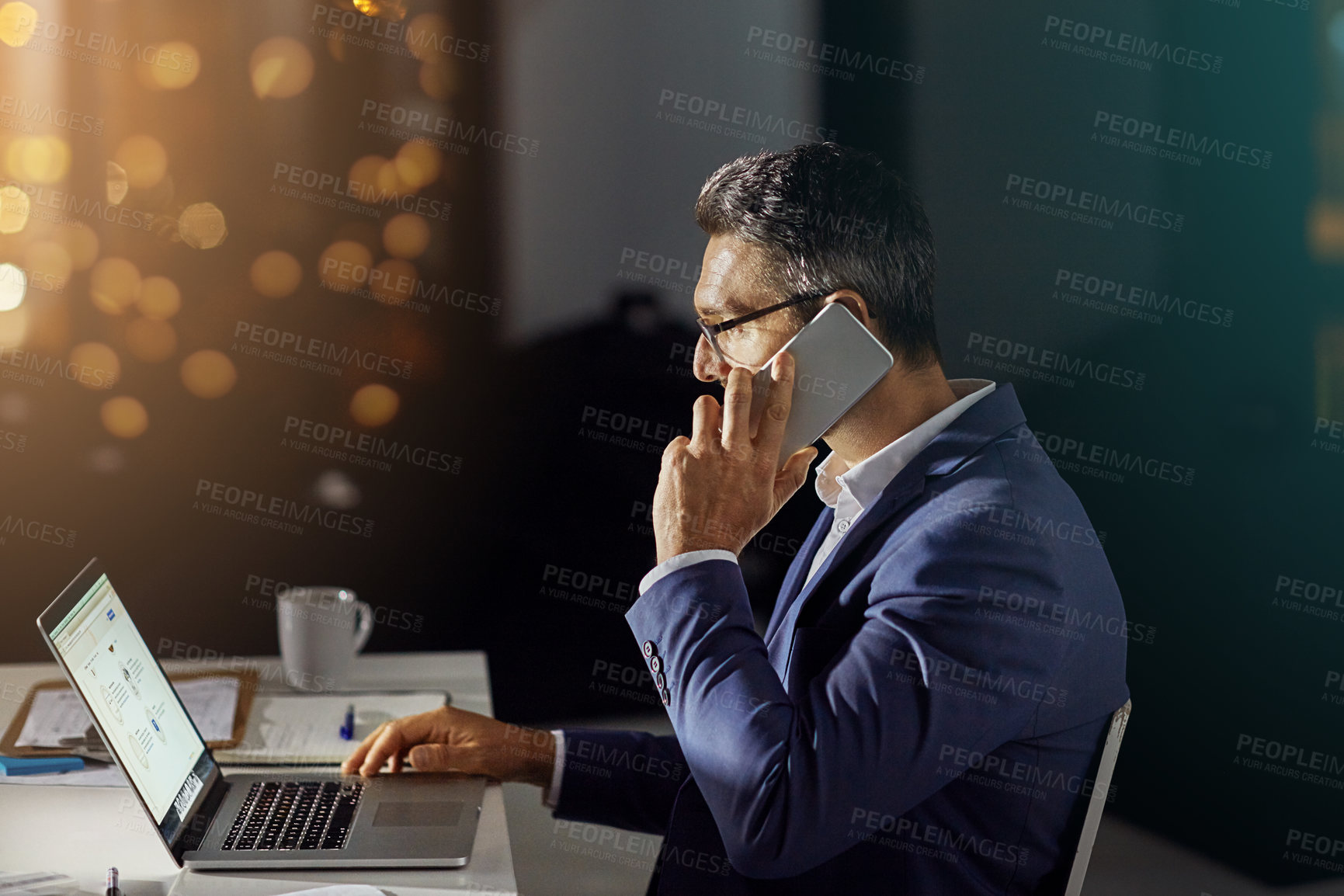 Buy stock photo Shot of a businessman using his phone while woking late in the office