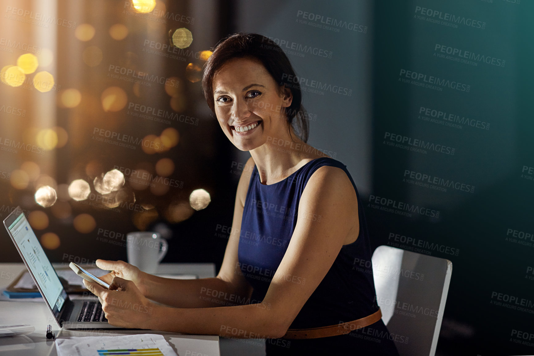 Buy stock photo Portrait of a businesswoman using her phone while woking late in the office