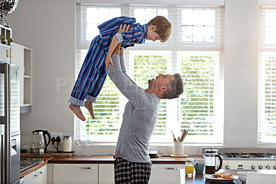 Buy stock photo Kitchen, dad and lifting boy in home for bonding, fun and love in morning with pajama. Apartment, people and parent for family time with smile for support, care and trust for child development