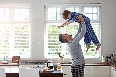 Buy stock photo Kitchen, dad and flying with boy for bonding, fun and love in morning with pajama. Apartment, people and parent for lifting with smile for support, care and playful for child development at home