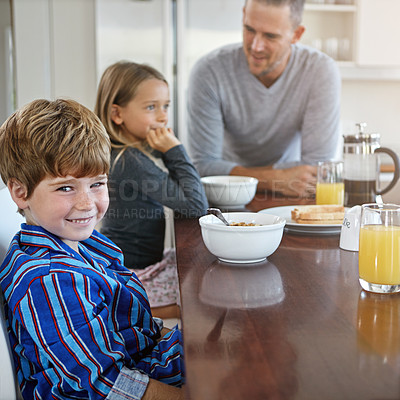 Buy stock photo Portrait of a young boy having breakfast together with his family at home
