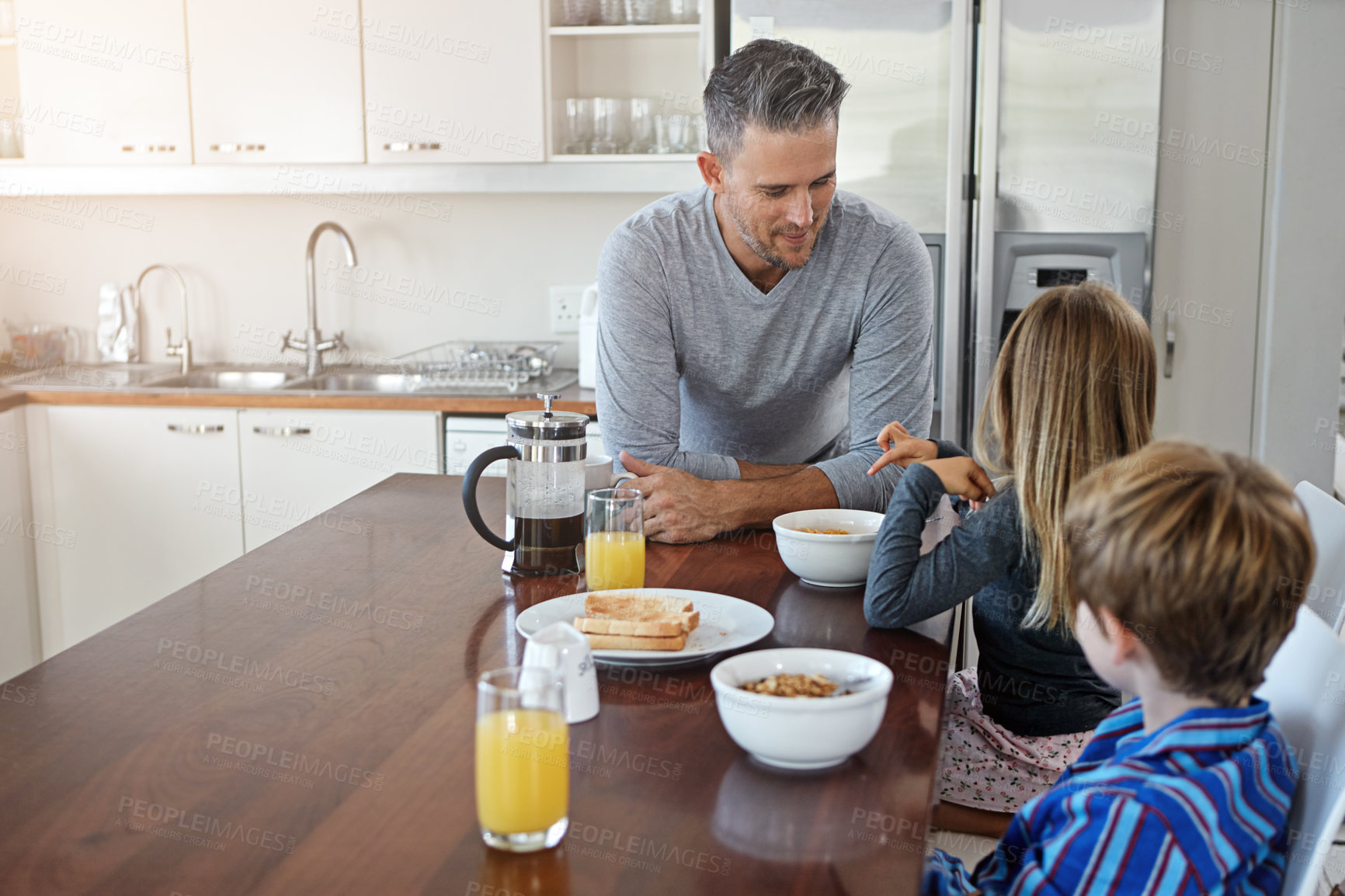 Buy stock photo Kitchen, eating and father with children for breakfast together on weekend for nutrition at home. Happy, bonding and dad enjoying morning food with kids for connection or family time in house.