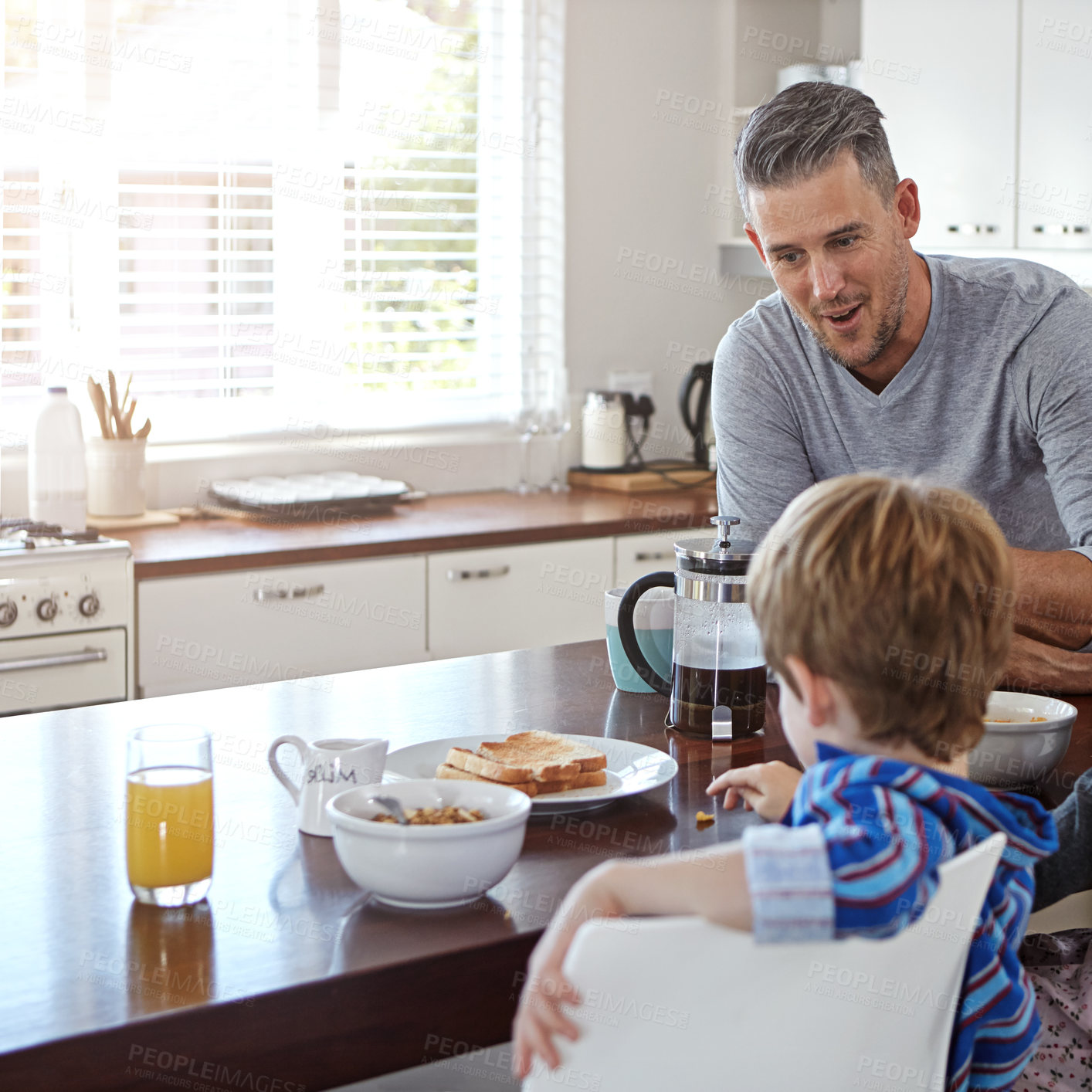 Buy stock photo Father, child and breakfast with cereal in kitchen for morning nutrition, vitamin C or orange juice at home. Dad, boy or son with healthy meal for calcium, snack or eating together on table at house