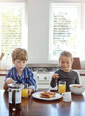 Buy stock photo Shot of two siblings having breakfast together at home