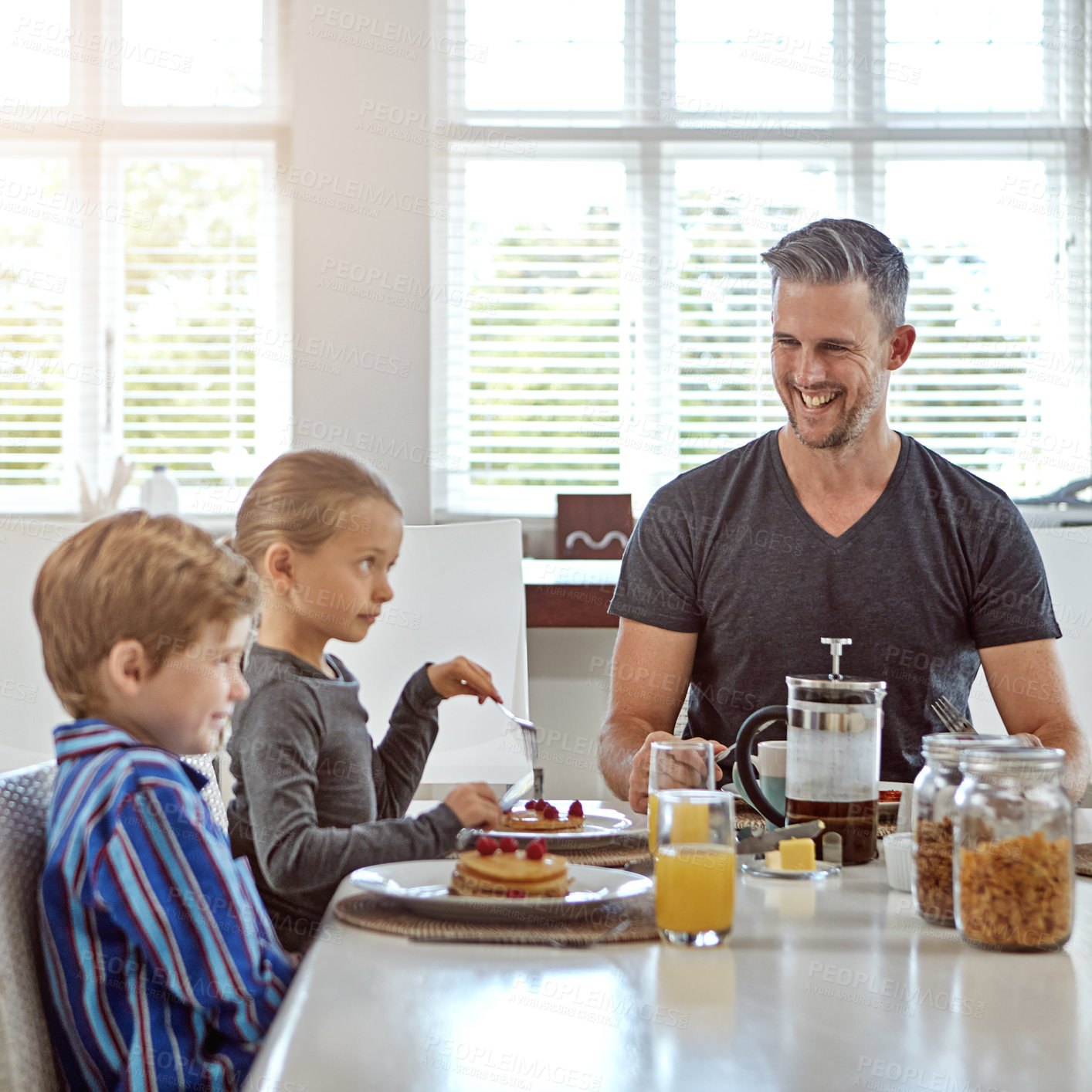 Buy stock photo Shot of a man enjoying breakfast with his two children