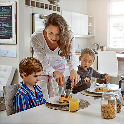 Buy stock photo Shot of two children having breakfast with their mother