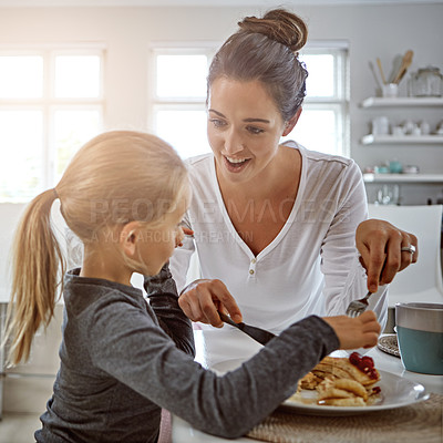 Buy stock photo Cropped shot of a mother and daughter having breakfast at home