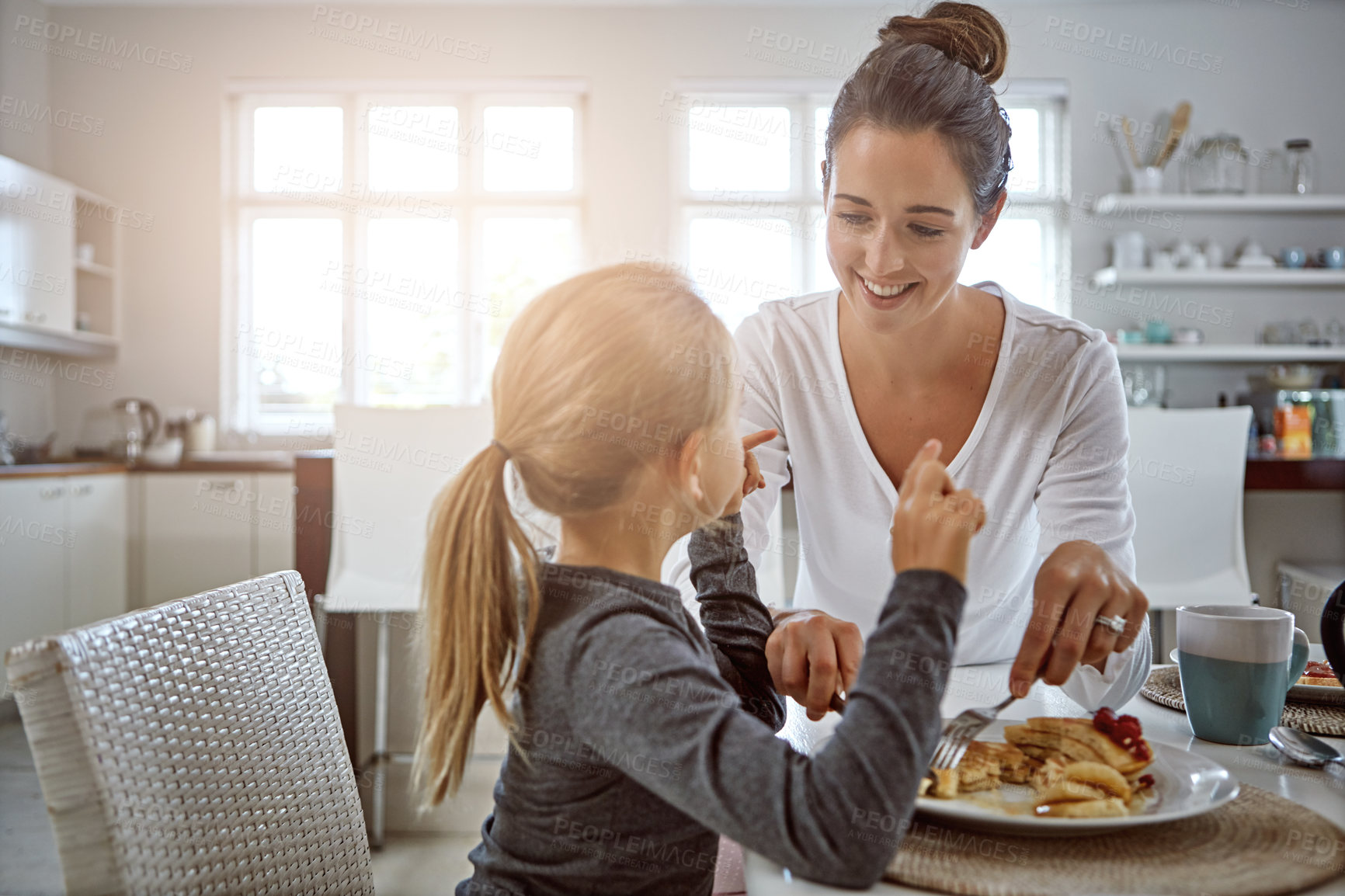 Buy stock photo Cropped shot of a mother and daughter having breakfast at home