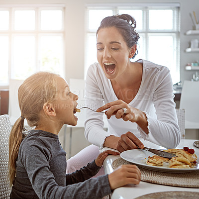 Buy stock photo Cropped shot of a mother and daughter having breakfast at home