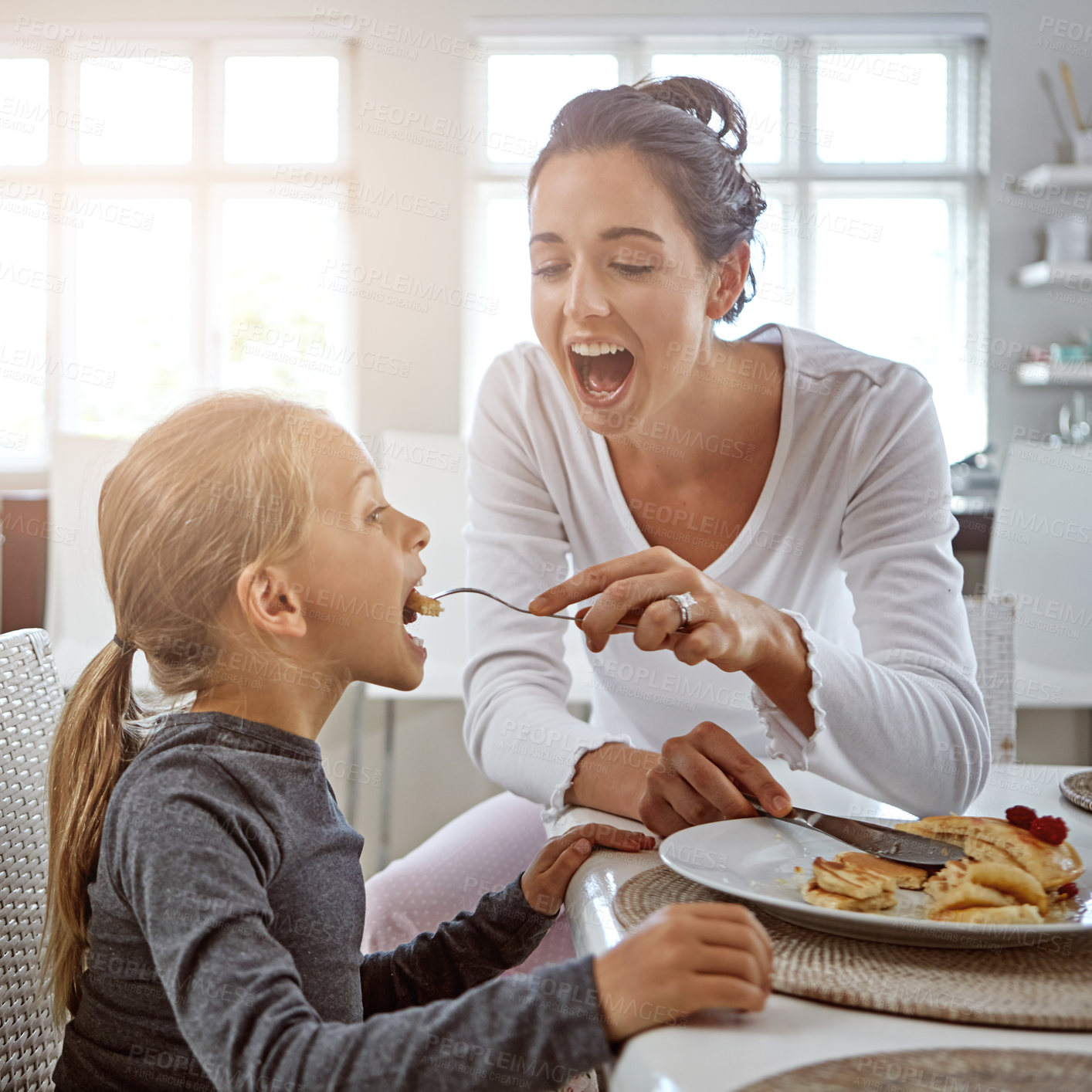 Buy stock photo Cropped shot of a mother and daughter having breakfast at home