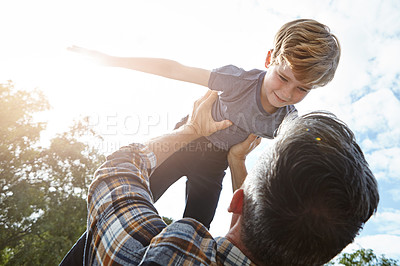 Buy stock photo Shot of a father lifting his son high into the air