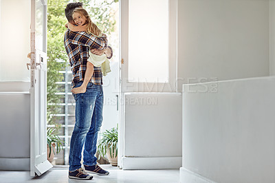 Buy stock photo Shot of a father picking up his daughter as he enters his house