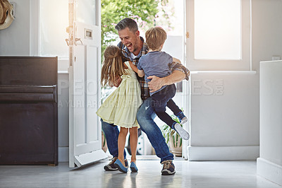 Buy stock photo Shot of a father embracing his two children as he enters the house