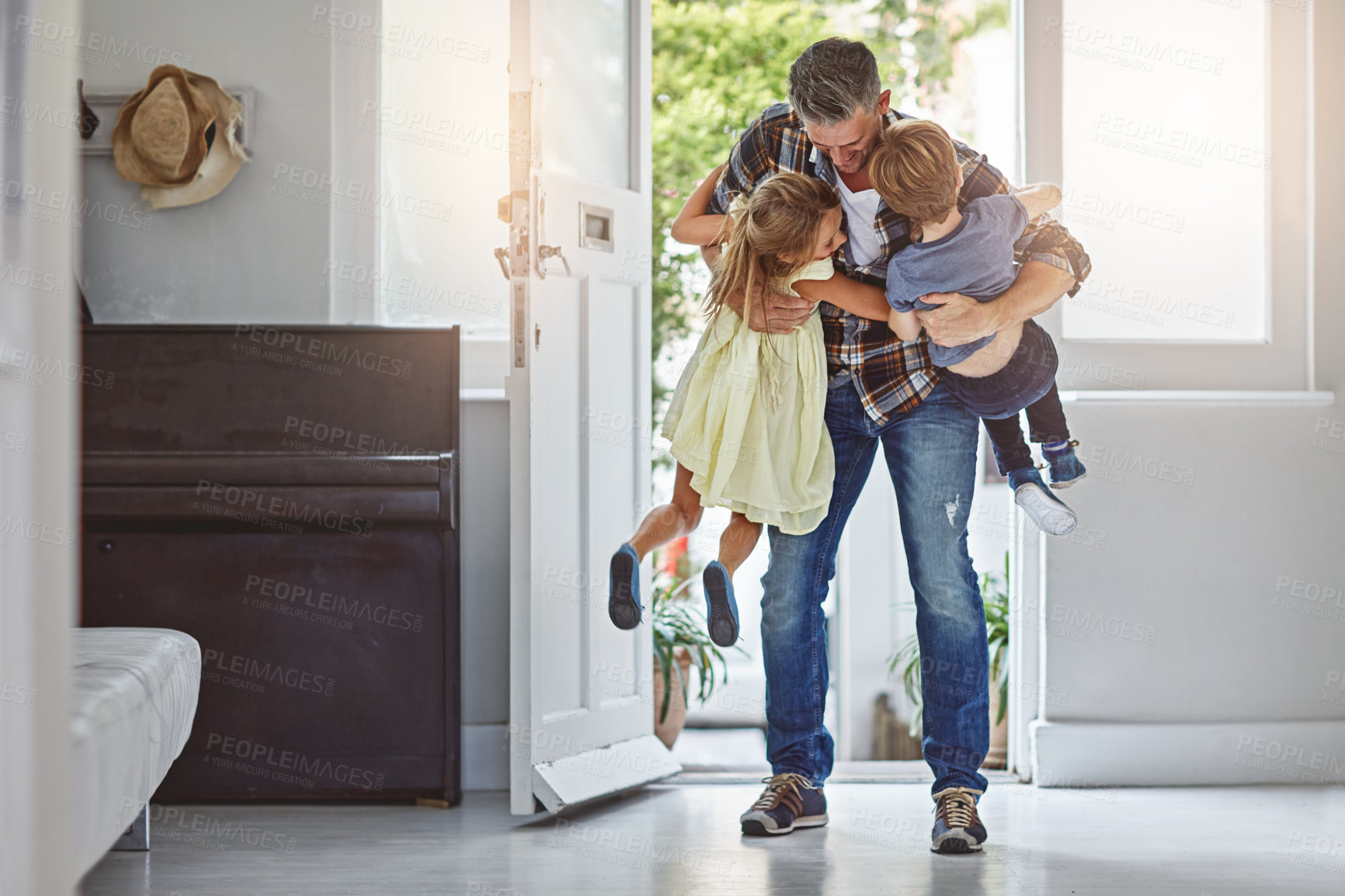 Buy stock photo Hug, welcome and a father with children at front door, greeting after work and excited to be home. Happy, family and a dad hugging a girl and boy kid after arriving from a job with love in a house