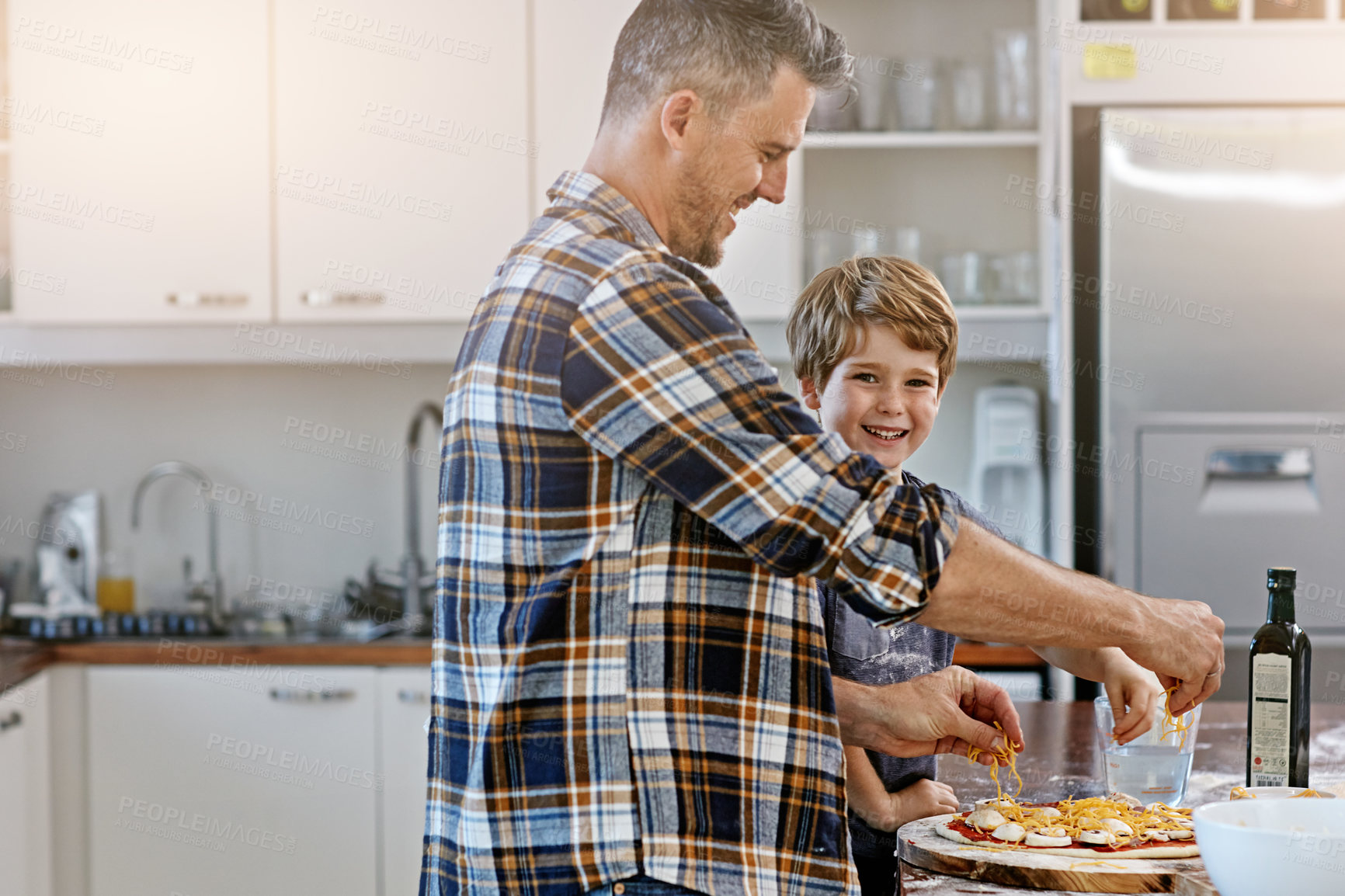 Buy stock photo Baking, dad and bonding with child, pizza and happy with son in kitchen, teaching and ingredients. Home, learning and help for father, meal prep and parent with boy, dinner and recipe for food