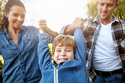 Buy stock photo Shot of a happy little boy having fun with his mom and dad outdoors