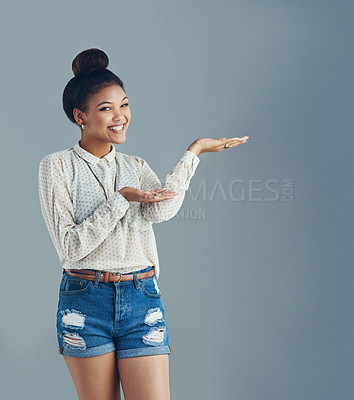 Buy stock photo Studio portrait of an attractive young woman holding copyspace against a gray background