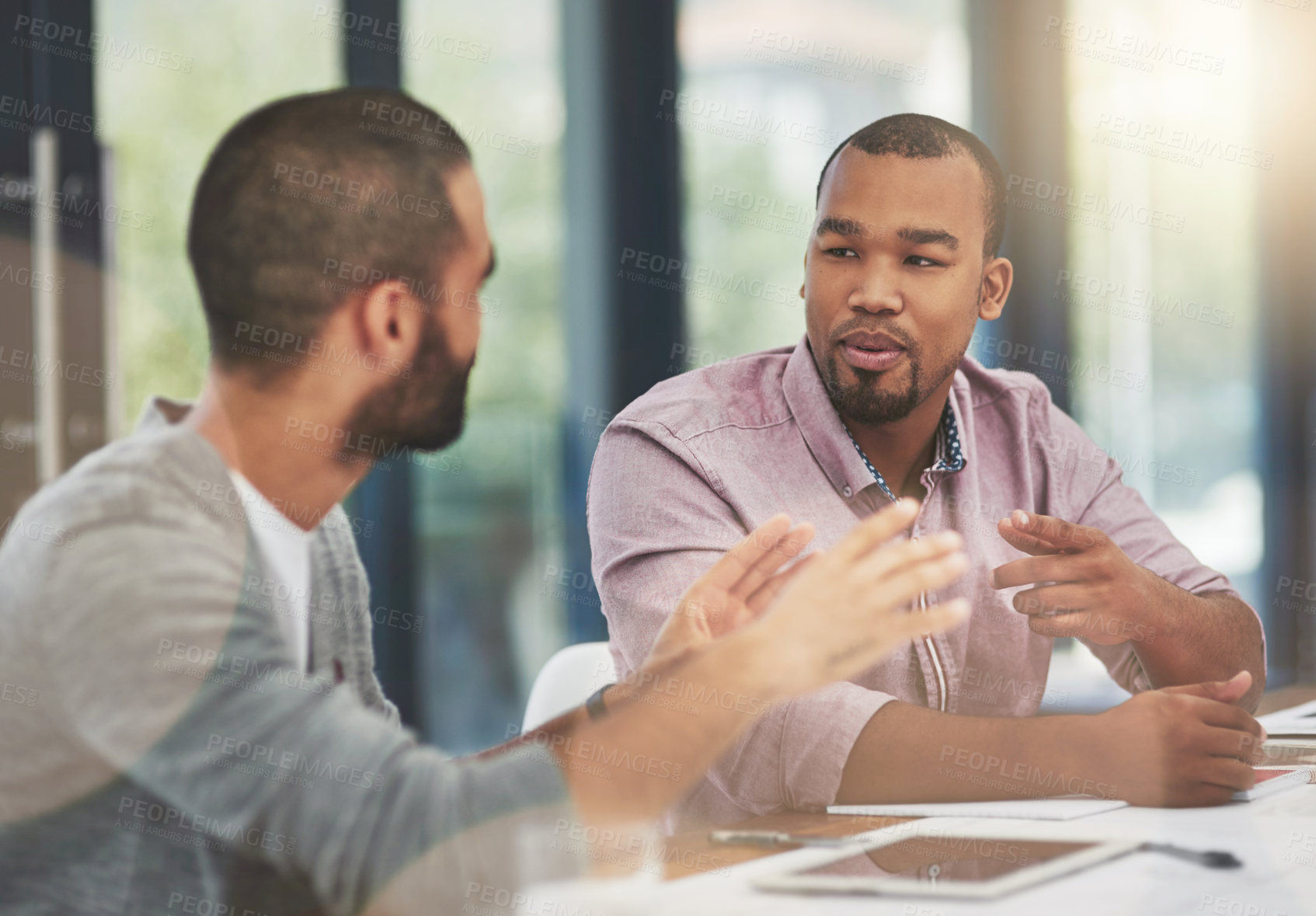 Buy stock photo Cropped shot of two young businessmen in a meeting