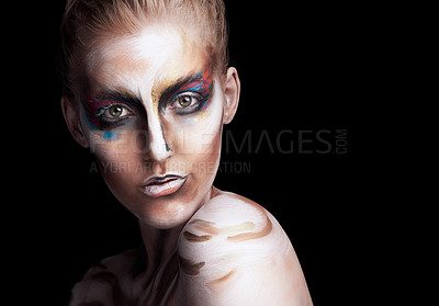 Buy stock photo Studio portrait of a young woman posing with paint on her face isolated on black