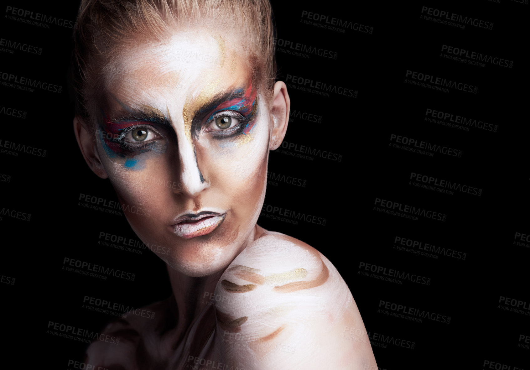 Buy stock photo Studio portrait of a young woman posing with paint on her face isolated on black