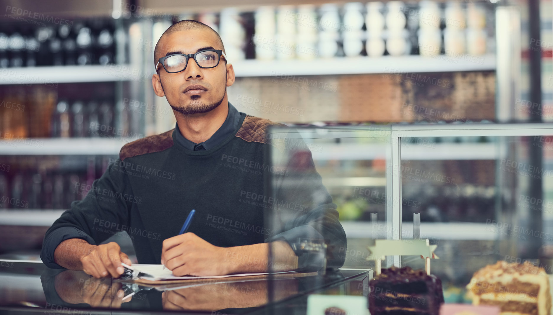 Buy stock photo Clipboard, thinking and writing with man in coffee shop for inventory or stock inspection and planning. Checklist, glasses and idea with store owner in cafe for management of small business startup