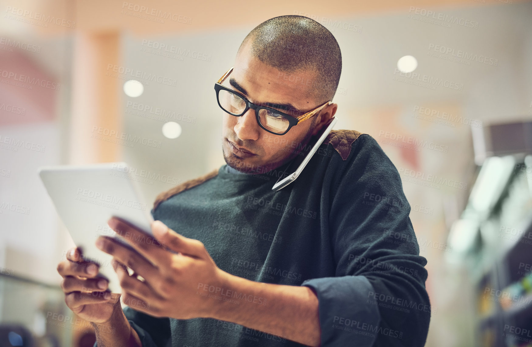 Buy stock photo Shot of a man talking on his cellphone in a coffee shop while using a digital tablet