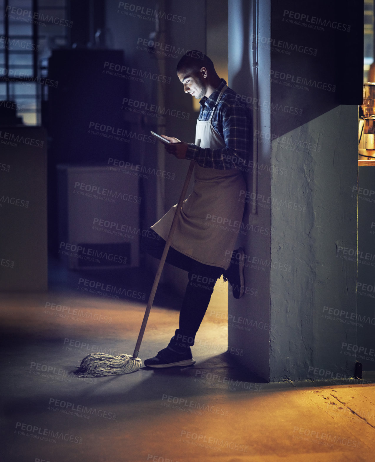 Buy stock photo Man, relax and tablet at night in cafe with mop for cleaning, inventory information and typing feedback. Male owner, digital and overtime with maintenance inspection, communication and shop hygiene
