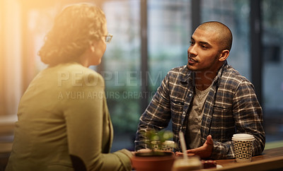 Buy stock photo Cropped shot of a young couple sitting in a coffee shop