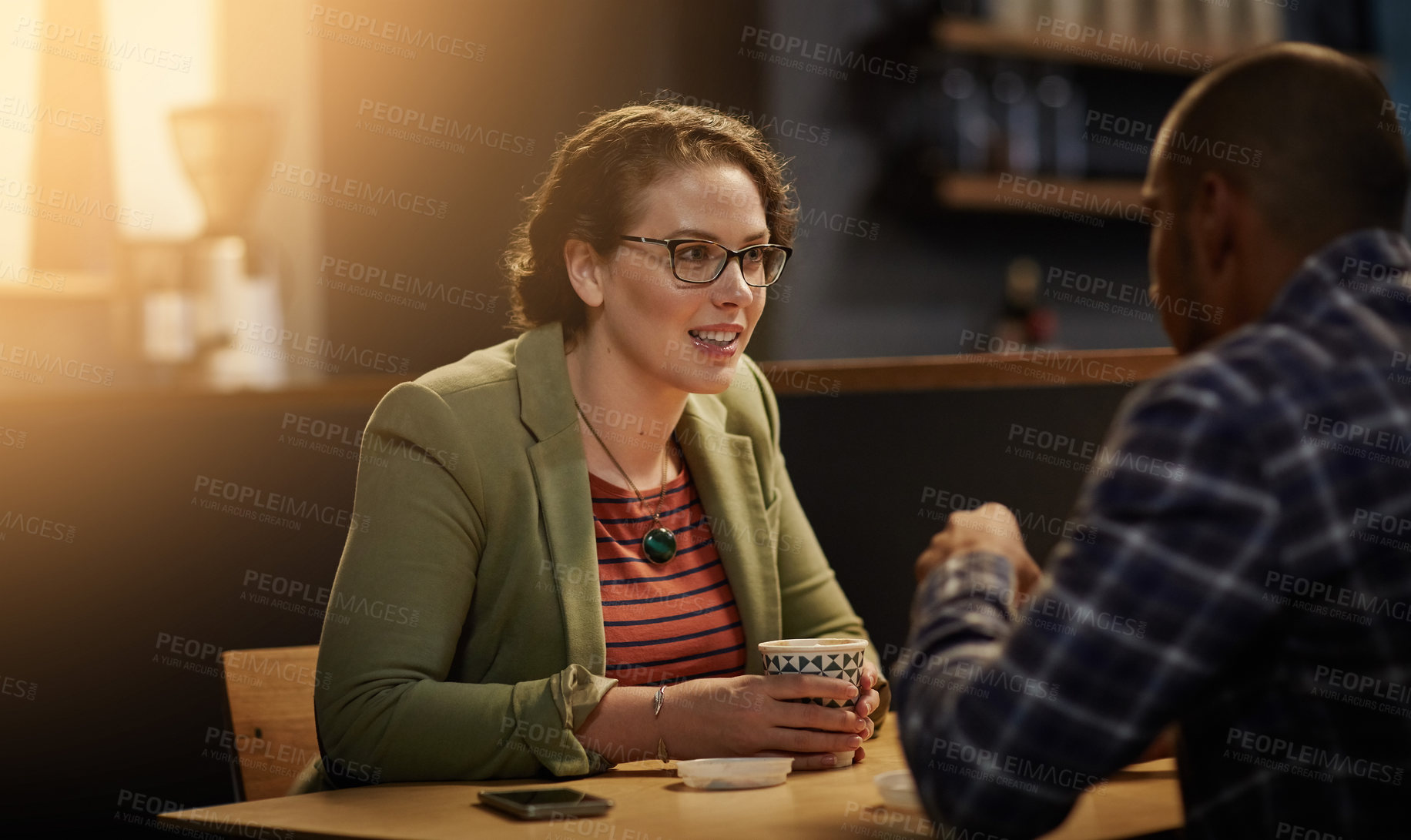 Buy stock photo Cropped shot of a young couple sitting in a coffee shop