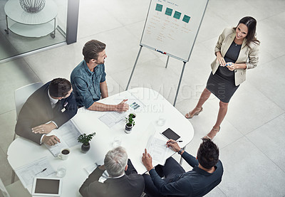 Buy stock photo High angle shot of a businesswoman giving a presentation to colleagues sitting around a table in an office