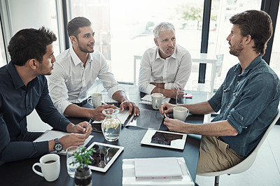 Buy stock photo Shot of a group of businessmen having a meeting around a table in an office