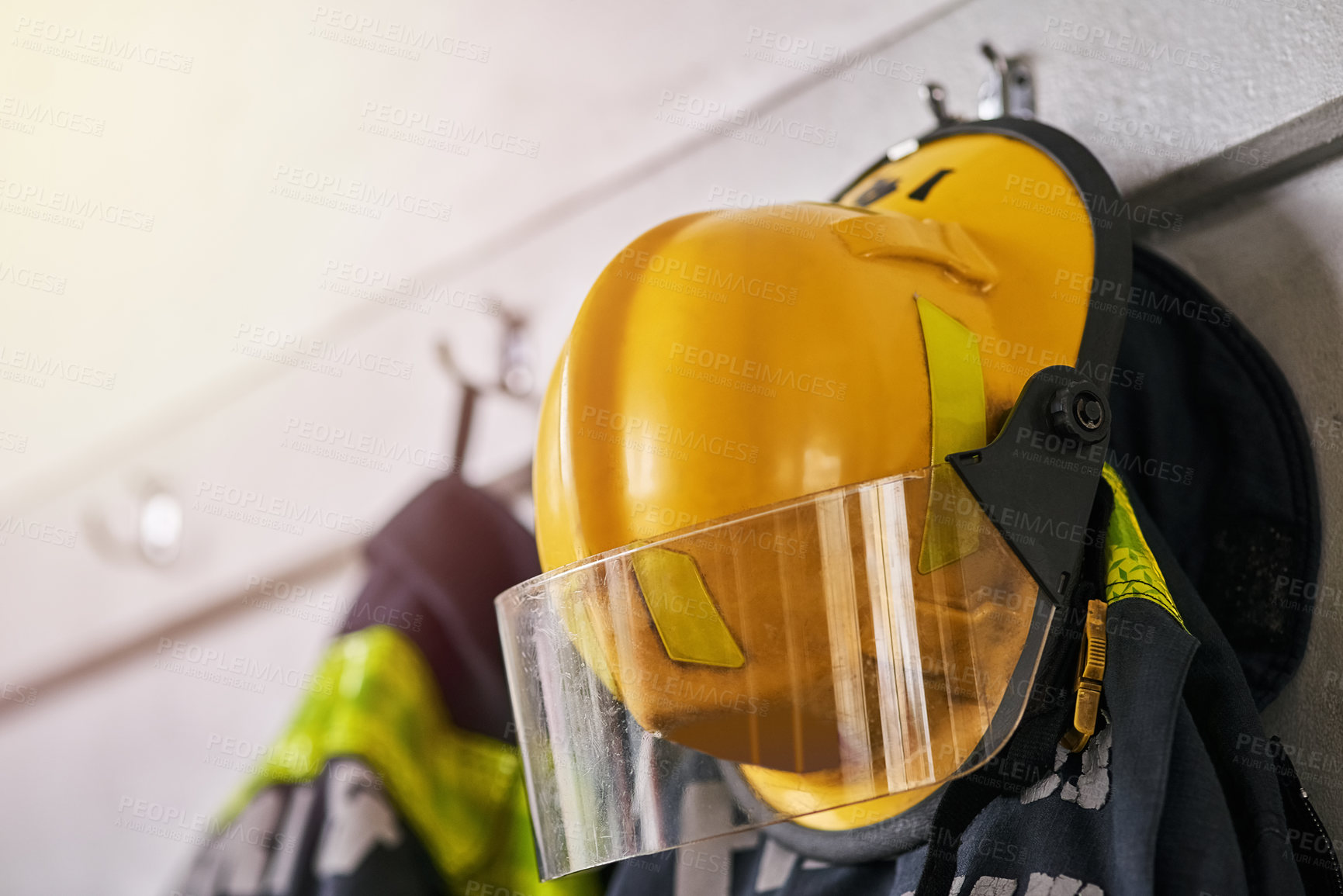 Buy stock photo Helmet, clothes and fire fighter for safety gear in emergency service, security and hero, courage or risk. Rescue uniform in department with protection and ppe on hanger, ready for danger or accident