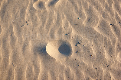 Buy stock photo Closeup of sand texture on a beach in summer as background. Brown desert pattern from tropical beach. Desert sand dunes texture. Rippled shore with tiny stones