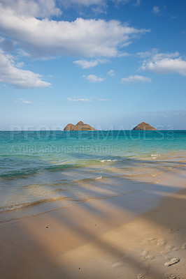 Buy stock photo A landscape view of crystal clear ocean water with sand and island. A bright sky with white clouds. A picture with shadows and footsteps on the sand. A shot of wavy blue ocean displaying mix texture.