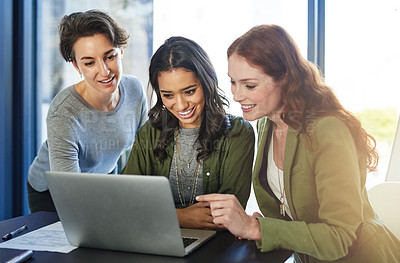 Buy stock photo Shot of a group of businesswomen working on a laptop in an office