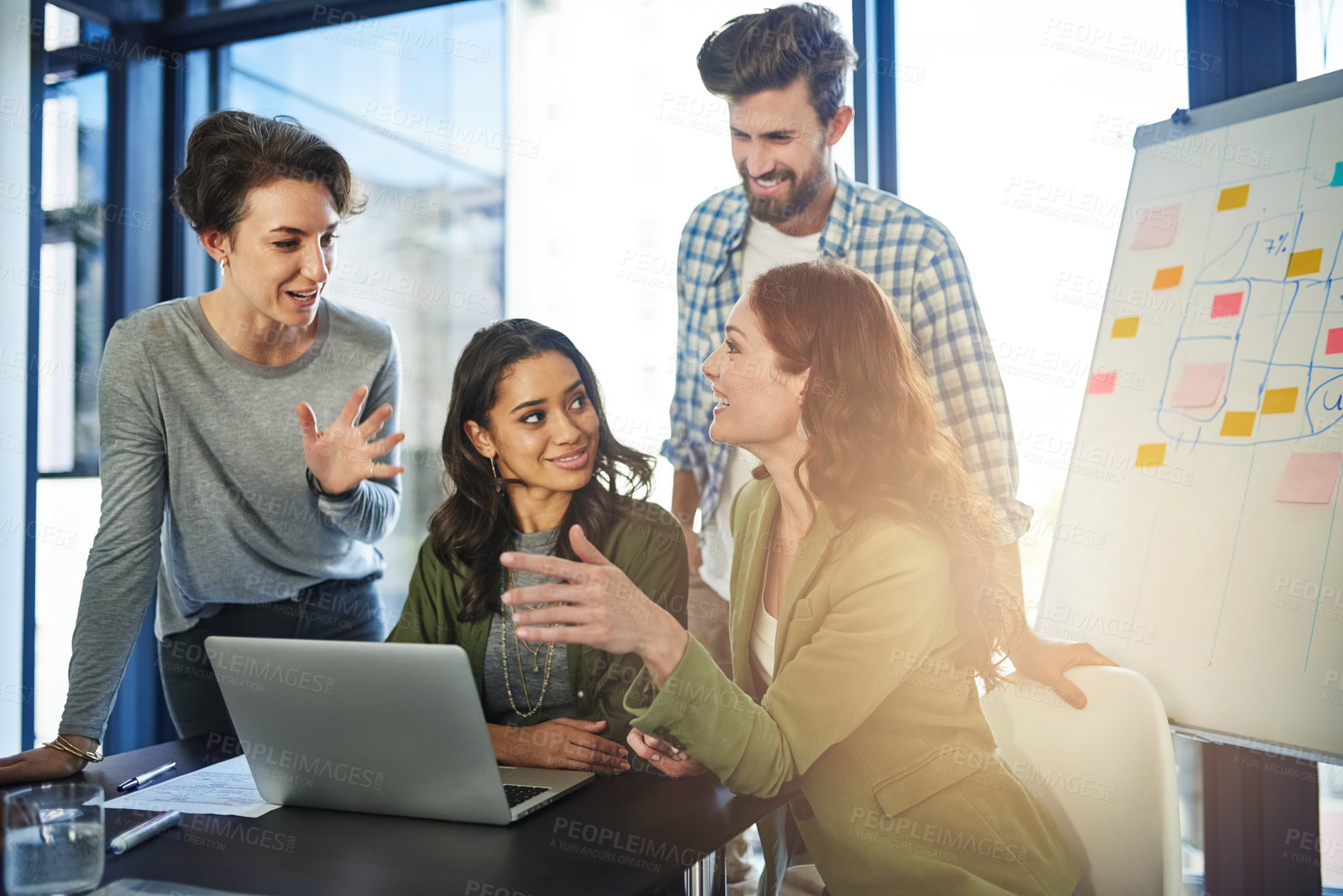 Buy stock photo Shot of a group of colleagues working on a laptop in an office