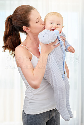 Buy stock photo Family, love and mother kissing baby in home together for morning bonding, relationship or trust. Bedroom, growth and kids with young woman holding infant in apartment for care or child development