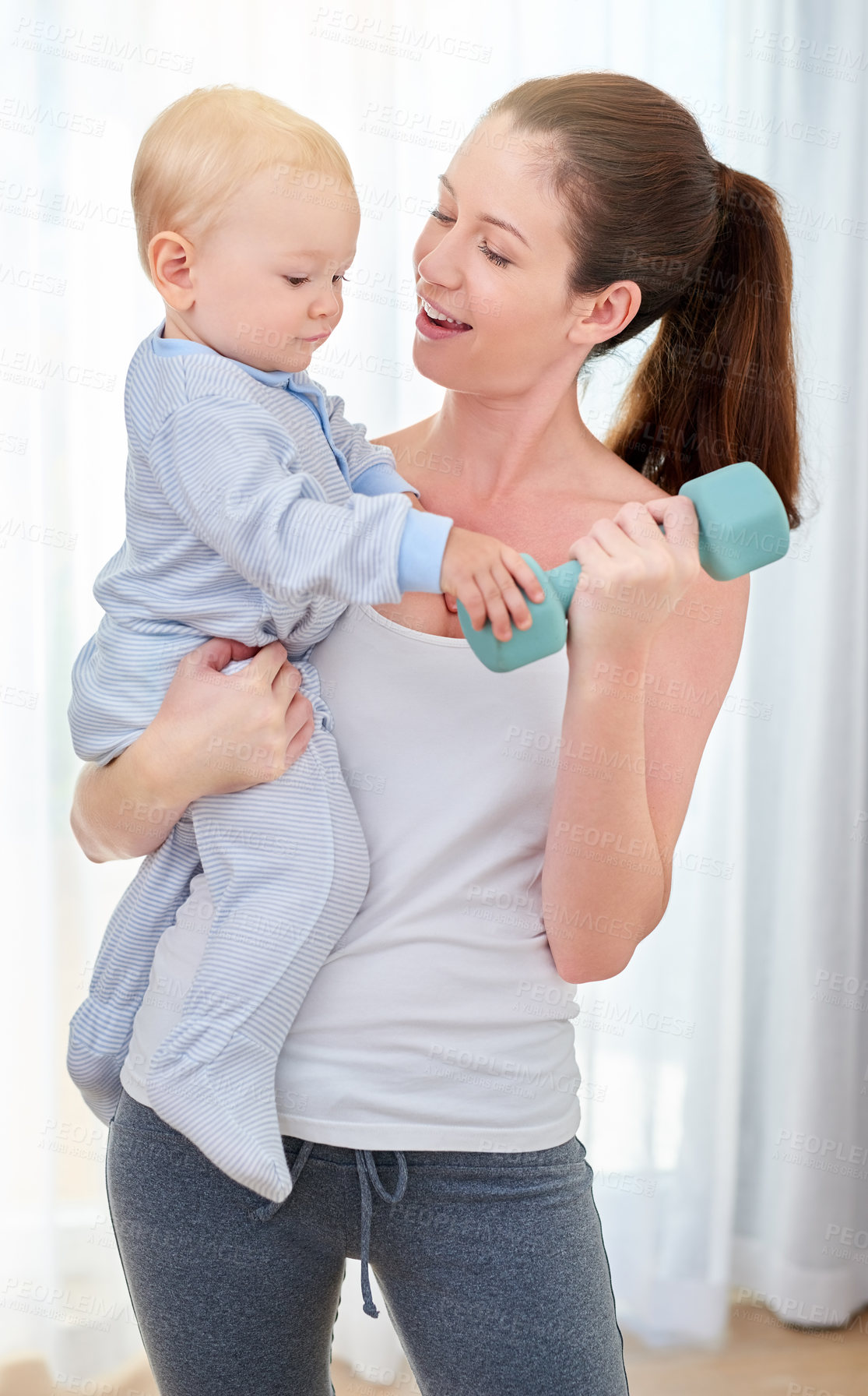 Buy stock photo Shot of a young woman working out while spending time with her baby boy