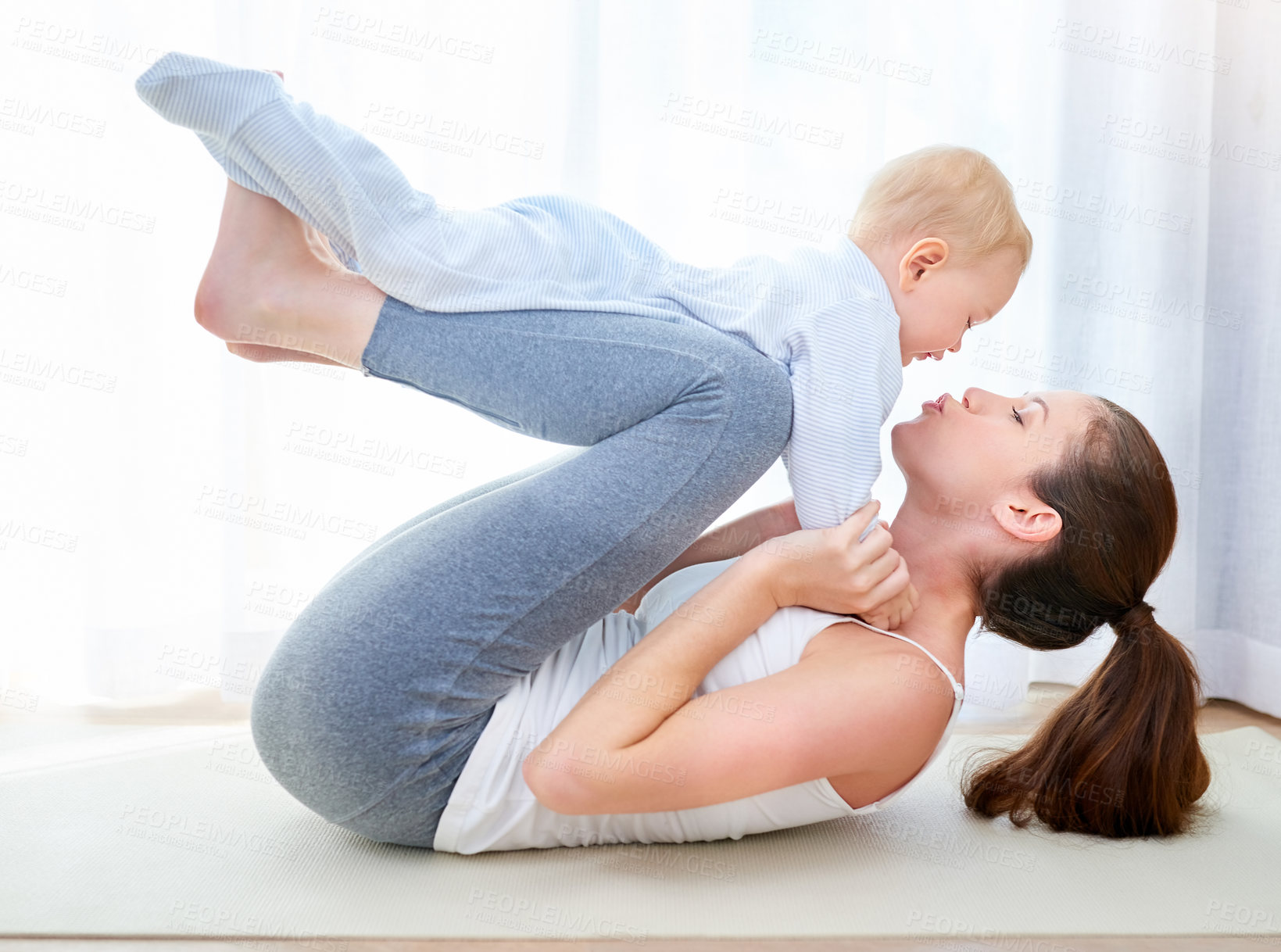 Buy stock photo Shot of a young woman working out while spending time with her baby boy