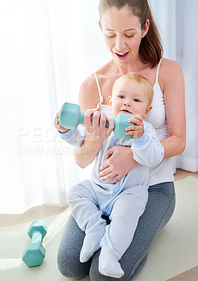 Buy stock photo Shot of a young woman working out while spending time with her baby boy