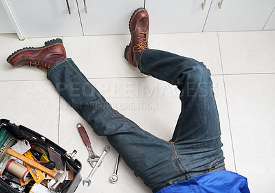 Buy stock photo Cropped shot of a handyman conducting repairs on the floor next to his tool box