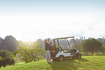 Buy stock photo Shot of a young couple choosing their clubs while enjoying a day on the golf course