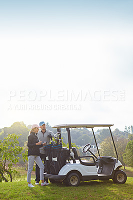 Buy stock photo Shot of a young couple choosing their clubs while enjoying a day on the golf course